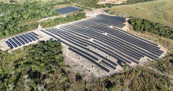 Vista aérea de usina solar com fileiras de painéis fotovoltaicos instalados em terreno aberto, ilustrando aplicação de energia renovável em estratégias de sustentabilidade empresarial e logística verde.